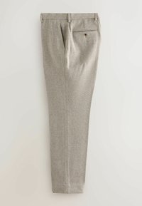 Bukser i lys grå herringbone-stof med en skræddersyet pasform, der har en baglomme med knap og plisseret frontdetalje.