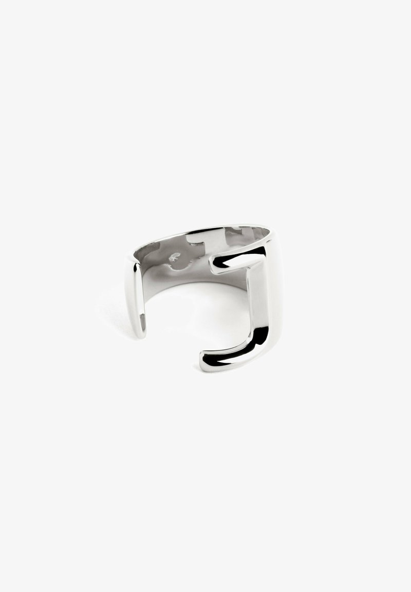 Anello in argento con finitura lucida, caratterizzato da un design aperto unico con una prominente forma della lettera 'J' nella parte frontale, superficie liscia.