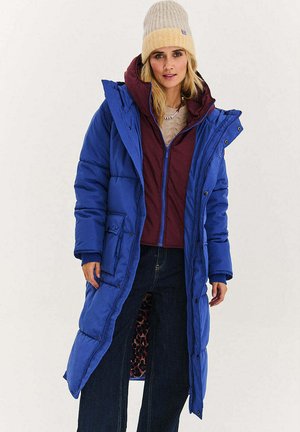 Niebieska kurtka puchowa z kapturem, zapinana na zamek błyskawiczny, z bocznymi kieszeniami oraz bordową wewnętrzną kurtką. Materiał gładki, z miękkim podszyciem.