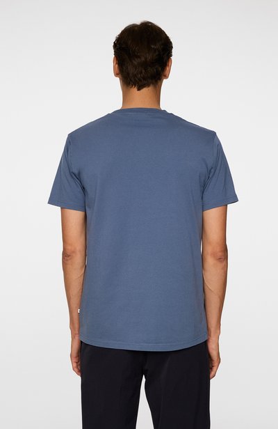 T-shirt à manches courtes, col rond en bleu, présentant un design uni, en tissu de coton, avec une coupe décontractée et un ourlet surpiqué.