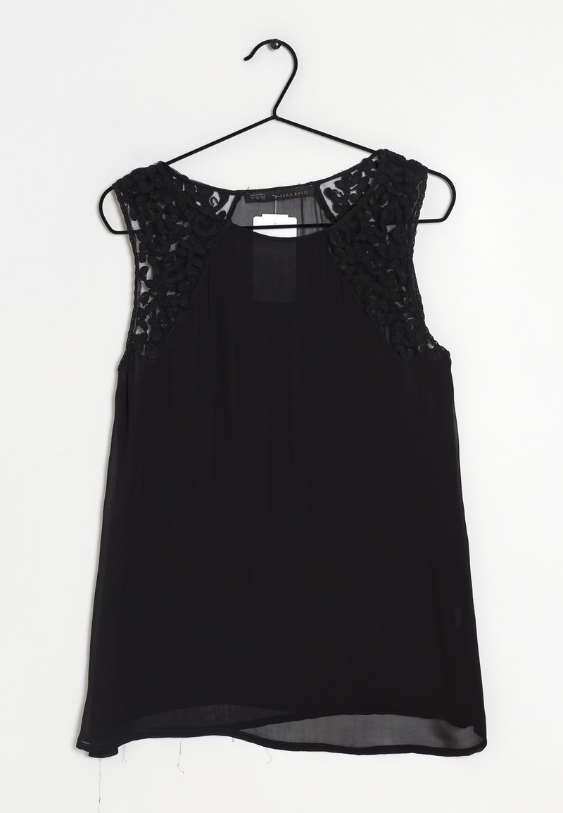 Zwarte mouwloze top met gestructureerde zwarte kantpanelen op de schouders, lichtgewicht stof en een iets gebogen zoom. Hangt aan een zwarte haak.
