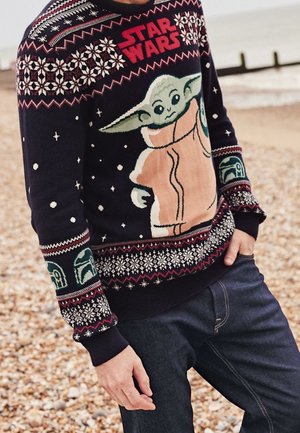 Ciemnogranatowy sweter z dużym wzorem przedstawiającym Baby Yodę, płatki śniegu oraz napis "STAR WARS". Dzianinowy wzór z czerwonymi i białymi akcentami.