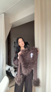 Pull marron côtelé avec un col et des poignets en fausse fourrure, doté d'un décolleté en V. Le matériau semble doux et texturé.