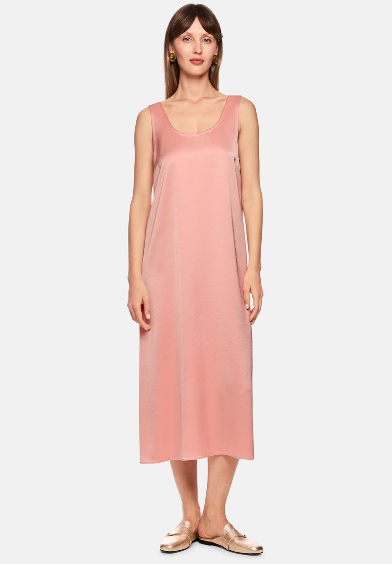 Blassrosa ärmelloses Midikleid mit Rundhalsausschnitt, glattem Satinmaterial und lockerem Schnitt, kombiniert mit hellen metallisch glänzenden Schlupfschuhen.