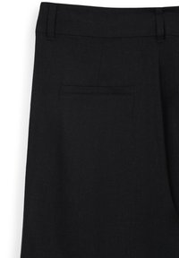 Pantalons en lin noir avec une texture lisse, dotés d'une poche arrière simple et d'une coupe ajustée. Coupe droite avec passants de ceinture.