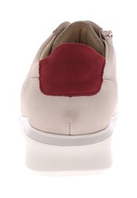 Helle beiges Schuhwerk mit strukturierter Oberfläche, rotem Wildlederakzent an der Ferse und weißer Gummisohle. Die Rückansicht zeigt keine sichtbaren Beschläge oder Muster.