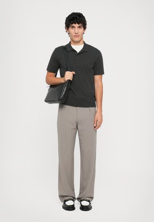 Camisa polo gris oscuro, pantalones ajustados gris claro, sandalias negras y un bolso de cuero negro, con texturas suaves y un ajuste relajado.