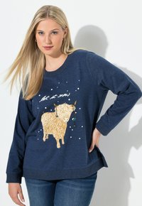 Granatowy sweatshirt z grafiką złotego szkockiego bydła, napisem "niech pada śnieg" oraz białymi akcentami w postaci płatków śniegu. Długie rękawy i luźny krój.