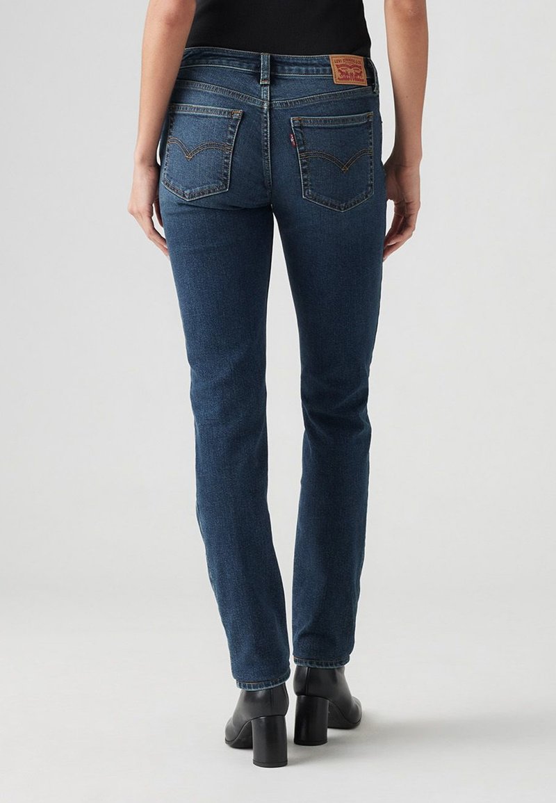 Jeans dritti blu scuro in denim, con vita alta, due tasche posteriori e un'etichetta in pelle marrone del marchio sopra la tasca destra.