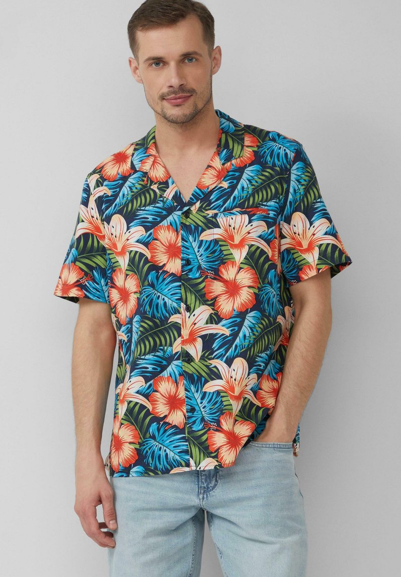 Camicia a maniche corte con stampa tropicale che presenta vivaci motivi floreali blu, arancioni e verdi su uno sfondo scuro, realizzata in tessuto leggero.