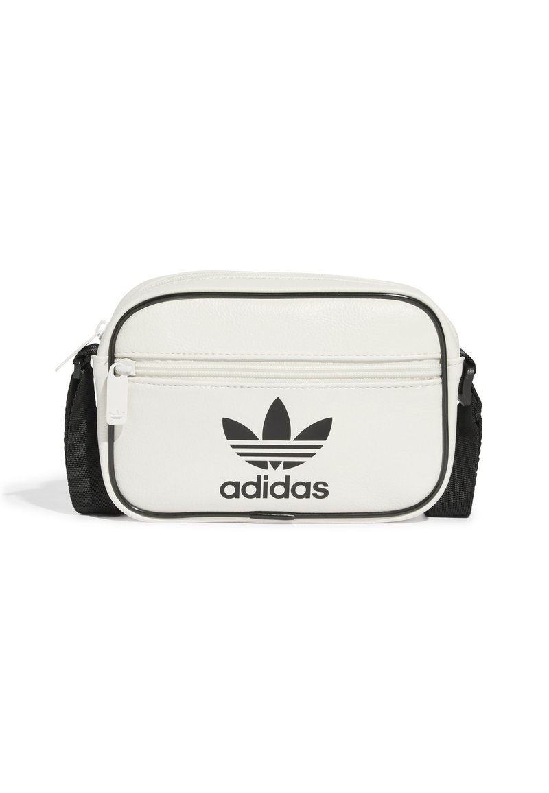 Bílá syntetická taška s černými akcenty, obsahující přední kapsu na zip, vyražené logo Adidas a nastavitelné ramenní popruhy. Obdélníkový tvar.