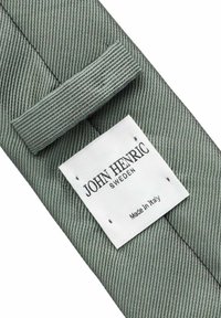 Vihreä teksturoitu solmio, jossa on hienovarainen raidoituskuvio. Solmiossa on valkoinen etiketti, jossa lukee "JOHN HENRIC SWEDEN" ja "Valmistettu Italiassa".