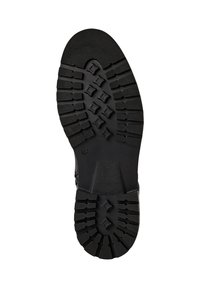 Semelle de botte noire avec des profondeurs de crampons, des grips en forme de diamant, un talon texturé, et le numéro de taille 42 visible près de l'arche.