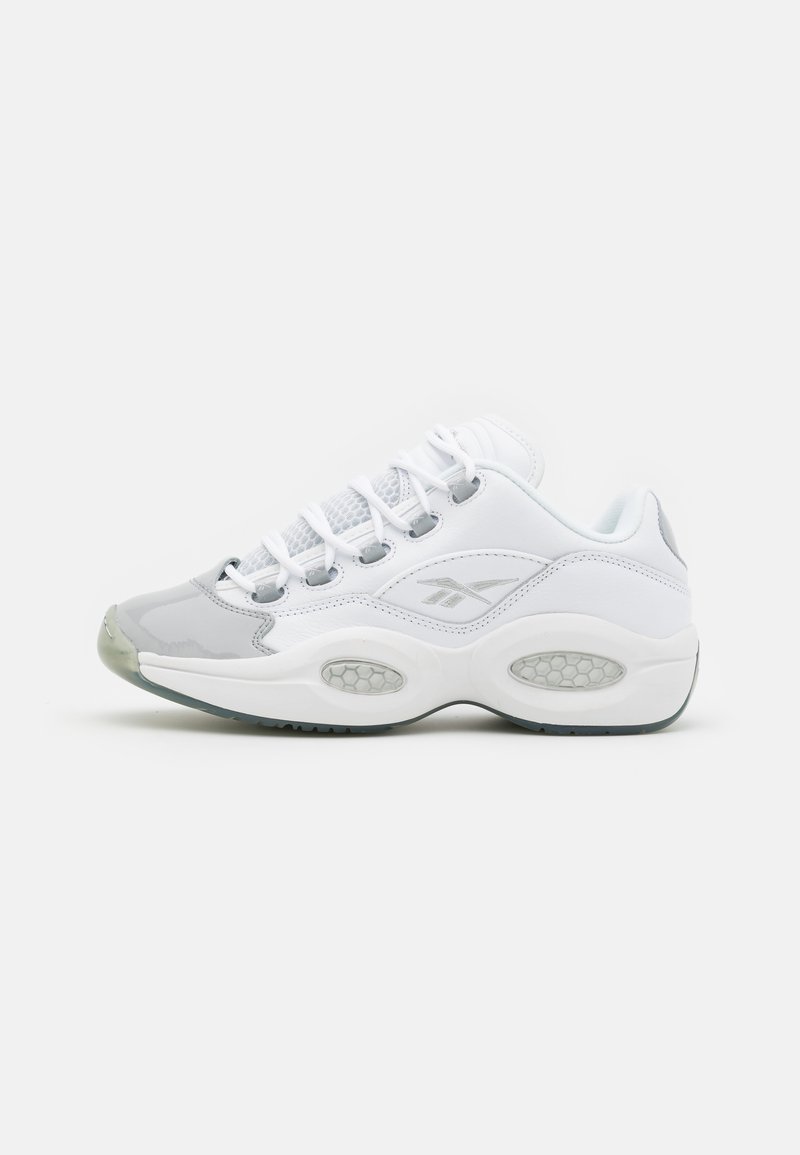 White athletic shoes with gray accents, mesh panels, and visible air cushioning. Features round laces and a smooth, glossy toe cap.