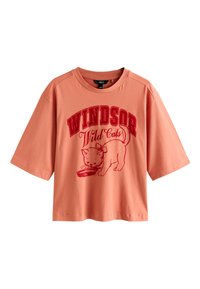Virsiku värvi puuvillane T-särk lühikeste varrukatega, millel on punane kassigraafika ja paksus kirjas tekst "Windsor Wild Cats".