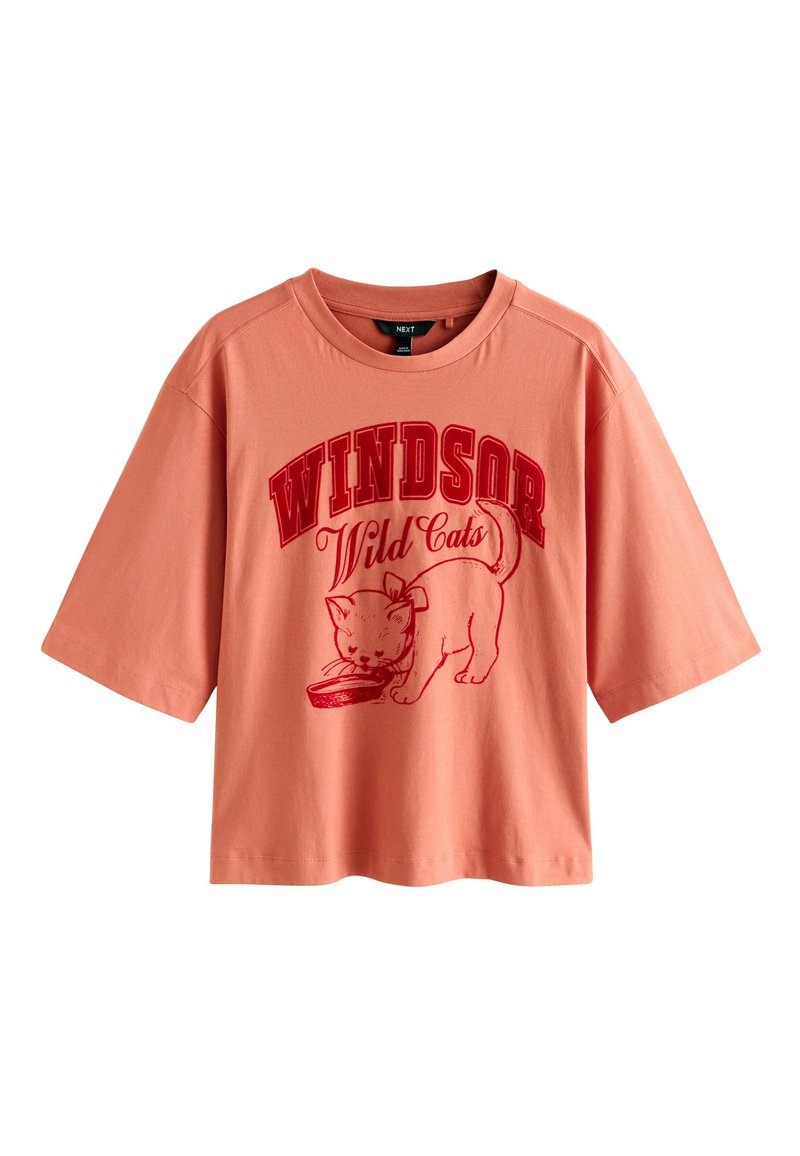 Virsiku värvi puuvillane T-särk lühikeste varrukatega, millel on punane kassigraafika ja paksus kirjas tekst "Windsor Wild Cats".