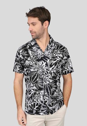 Chemise à manches courtes avec un imprimé floral noir et blanc, dotée d'un col classique, d'une fermeture à boutons et d'un tissu léger.