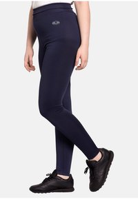 Navy blue leggings made of stretch fabric with a high waistband. Features a small lotus emblem on the front. Smooth texture, snug fit.