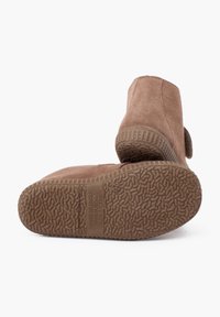 Stivaletti in suede marrone per bambini mostrati dal fondo e dal retro, con suole in gomma testurizzata marchiate con numero 26 e "Made in Spain".