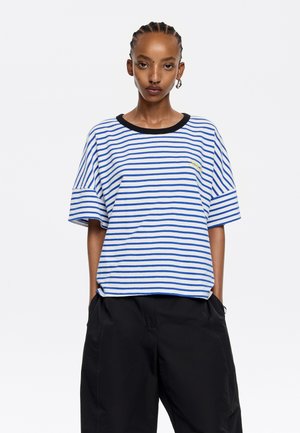 Camiseta de manga corta a rayas en azul y blanco con un cuello acanalado negro. Presenta un detalle bordado en el pecho.