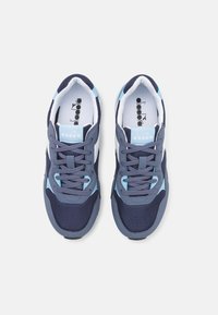 Sneaker blu navy e azzurri realizzati in materiali mesh e sintetici, con punta rotonda e chiusura con lacci, caratterizzati da dettagli del logo sulla linguetta.