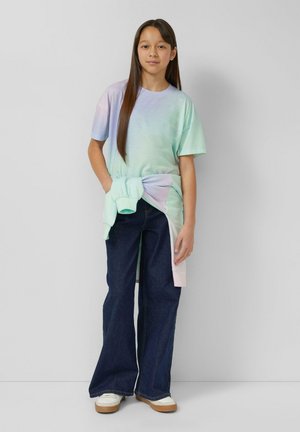 T-shirt z pastelowym gradientem i krótkimi rękawami, połączony z szerokimi jeansami i koszulą zawiązaną w talii. Gładka faktura, luźny krój.