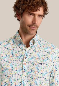 Korte mouwen shirt met een bloemenpatroon in blauw, oranje en groen op een witte achtergrond; knoopsluiting kraag met logo accent.