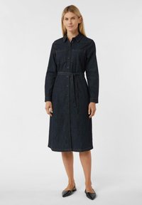 Sukienka koszulowa z denimu, ciemnoniebieska, z długimi rękawami, zapinana na guziki z przodu, z dwiema kieszeniami na piersi, z paskiem w talii, o długości midi, z kontrastowym przeszyciem, z czółenkami o spiczastym nosku.