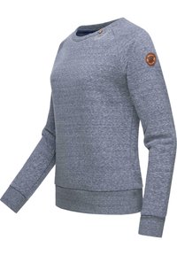 Sudadera gris de tejido suave y texturizado. Presenta un cuello redondo, puños acanalados y un parche con el logo en la manga izquierda. Corte clásico.