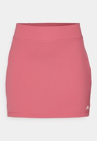 Růžová sportovní sukně vyrobená z hladké tkaniny, s přiléhavým pasem a detaily na spodním lemu, vhodná pro aktivní nošení.