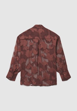 Chemise bordeaux transparente avec un motif floral, manches longues et col à boutons. Ornée de boutons dorés aux poignets.