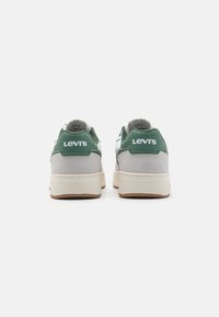 Zelené a šedé tenisky s svrchní částí z nubuku a kůže, které mají bílé logo Levi's na patě a béžovou gumovou podešví.