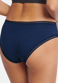 Mutande hipster in cotone blu navy con bordo in pizzo scallopato lungo il punto vita, caratterizzate da una superficie liscia e una vestibilità classica.