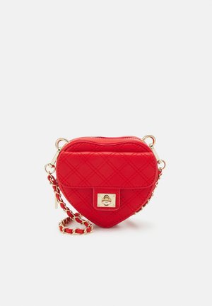Sac bandoulière rouge matelassé en forme de cœur avec bandoulière chaîne dorée et fermoir rectangulaire à tour sur la poche avant.