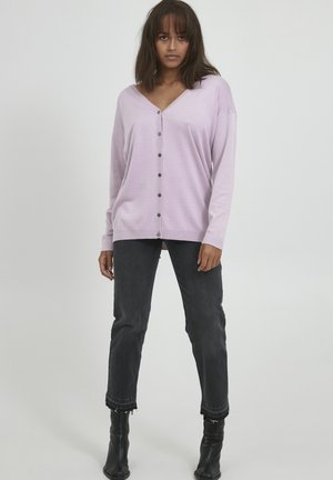 Hellblaues Button-Up-K cardigan mit V-Ausschnitt, langen Ärmeln und einer lockeren Passform. Kombiniert mit dunkelgrauen Jeans und schwarzen Stiefeletten.