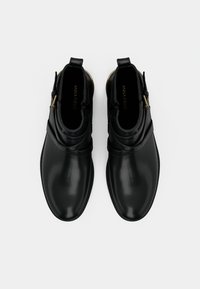 Čierne kožené členkové topánky s hladkým povrchom, s vrstvenými popruhmi cez zvršok, bočným zipsom a okrúhlou špičkou.