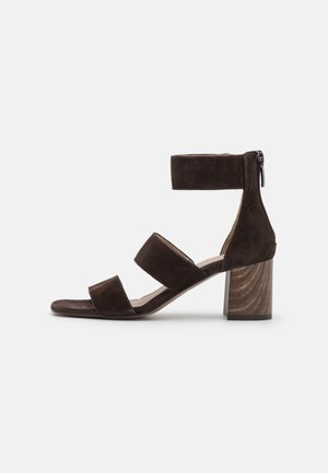 Sandale femme en daim marron avec talon bloc, trois brides incluant une bride de cheville avec fermeture éclair au dos, et un talon à texture bois.