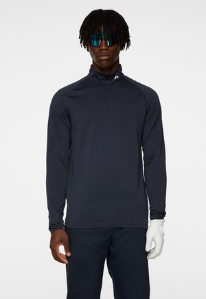 Marineblauw sportieve lange mouw top met een halve rits kraag, gemaakt van lichtgewicht stof. Kenmerkt zich door een logo op de borst en een getailleerd ontwerp.