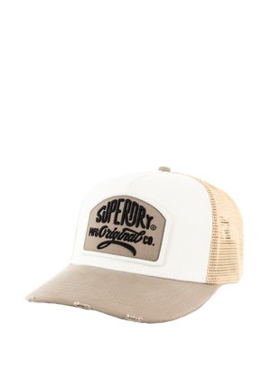 Casquette de baseball blanche et beige avec un écusson devant portant le texte "SUPERDRY MFG Original Co." Visière usée et arrière en mesh pour la ventilation.