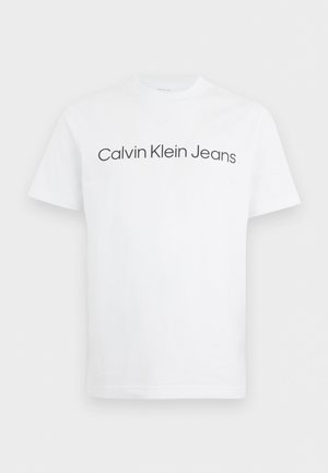 Weißes T-Shirt mit kurzen Ärmeln und Rundhalsausschnitt, auf der Brust ist "Calvin Klein Jeans" in Schwarz gedruckt.