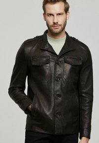 Zwarte leren jas met een kraagontwerp, twee borstzakken, knoopsluiting en een gestructureerde afwerking met schouderaccenten.