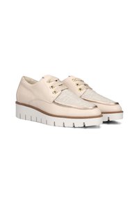 Beige leren schoenen met een textuurstof paneel, gouden vetertjes en een witte chunky zool met een lichte bruine accent.