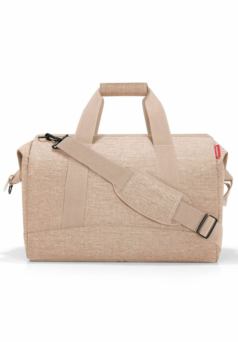 Borsa da viaggio in tessuto beige con due manici superiori e una tracolla staccabile. Presenta una chiusura con zip e un materiale testurizzato.
