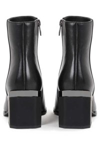 Stivaletti neri con finitura in pelle liscia, chiusura a zip e tacco rettangolare spesso con accenti metallici.