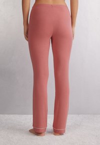 Lichte, zachte, roze pyjamabroek met een elastische tailleband en witte bies aan de boorden, met een rechte pijpdesign.