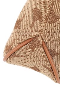 Tela marrón con estampado y acentos beige, que presenta una forma triangular estructurada y un borde de cuero en contraste. Detalles de textura sutiles visibles.