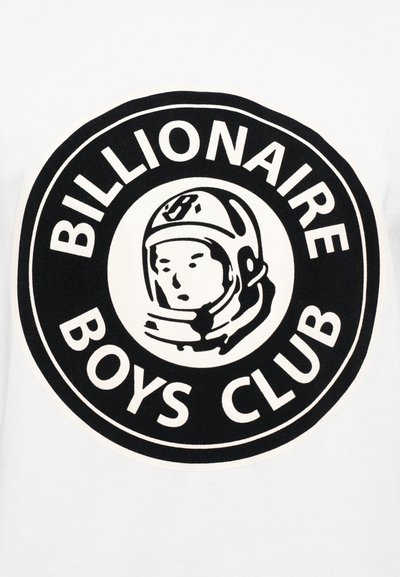 Valge t-särk, millel on ümmargune must graafika. Siseosas on stiliseeritud astronaudi pea, mille ümber on julgete tähtedega tekst "BILLIONAIRE BOYS CLUB".
