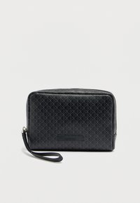 Μαύρο πορτοφόλι κατασκευασμένο από υλικό με υφή, με γεωμετρικό σχέδιο, φερμουάρ και λουράκι καρπού για εύκολη μεταφορά.