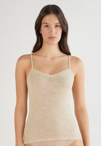 Beige Tanktop mit dünnen Trägern und V-Ausschnitt, hergestellt aus einem weichen, strukturierten Stoff mit leicht meliertem Muster. Eng anliegendes Design, mittellang.