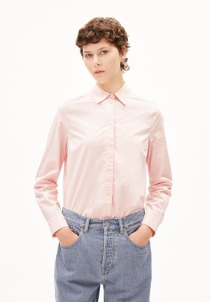 Lichtroze lange mouw shirt met een puntige kraag, voorzien van een knoopsluiting aan de voorkant en een gladde textuur, gecombineerd met hoge blauwe denim jeans.